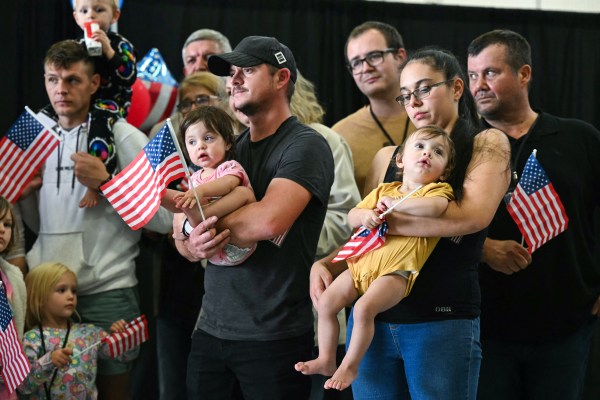 The first group of Afrikaners from South Africa to arrive for resettlement in the U.S. listen to remarks from Deputy Secretary of State Christopher Landau after they arrived at Washington Dulles International Airport in Virginia on May 12, 2025.  (Photo by Saul Loeb/AFP via Getty Images)