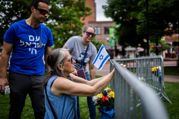 Lisa Turnquist of Louisville, Colorado, lays flowers and a flag at the site of the attack outside the Boulder County Courthouse on June 2, 2025, in Boulder, Colorado. (Photo by Chet Strange/Getty Images)