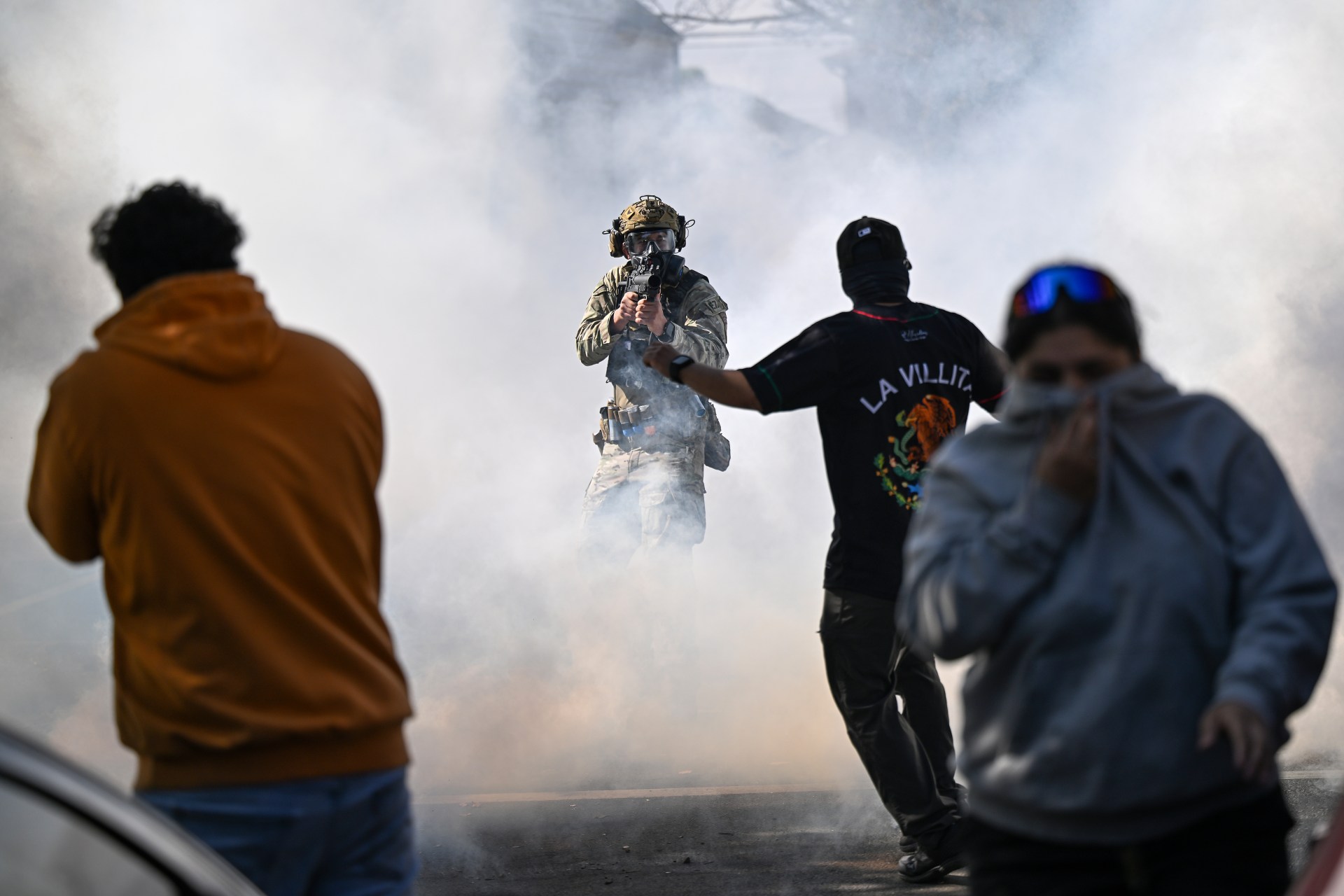 A man in a helmet with a gun in the air
