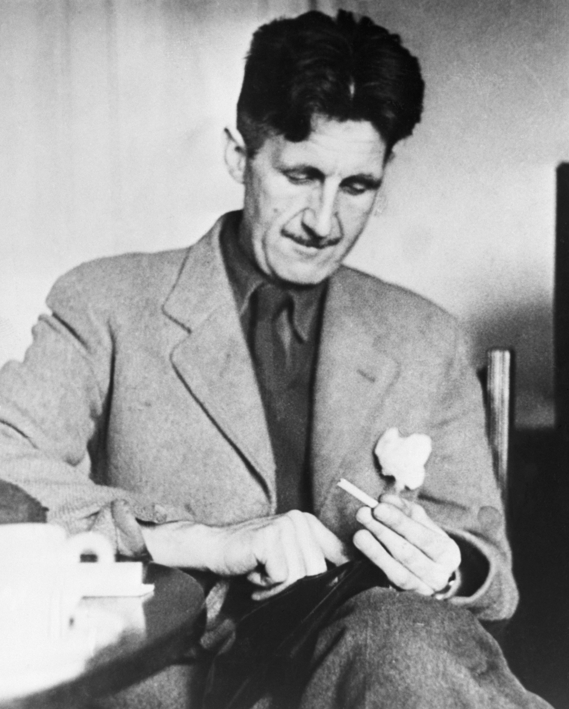 A man sitting at a table holding a cigarette
