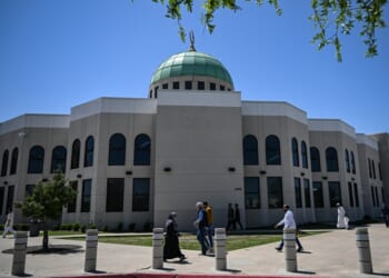 A group of people walking in front of a building