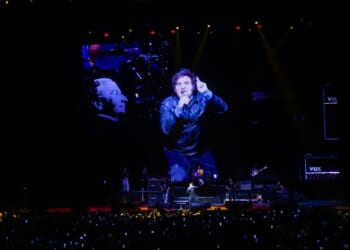 A man on a stage with a large screen