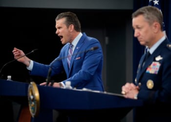 A man in a suit speaking into a microphone