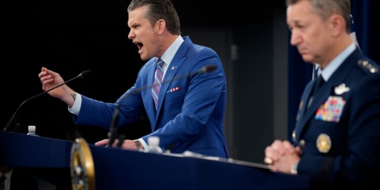 A man in a suit speaking into a microphone