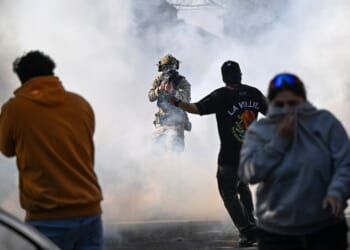 A man in a helmet with a gun in the air