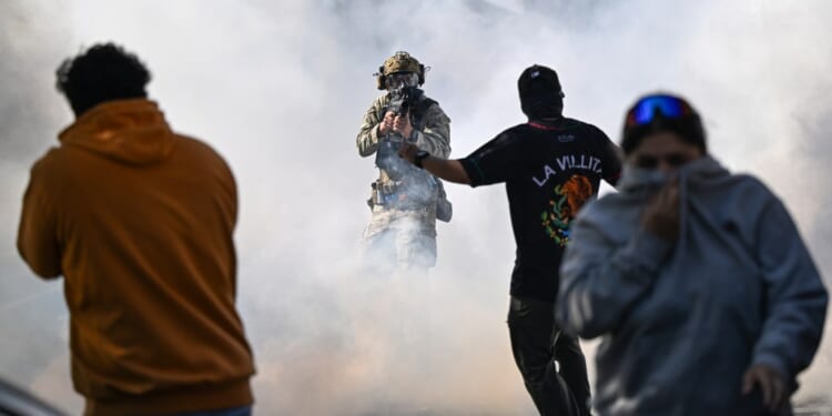 A man in a helmet with a gun in the air