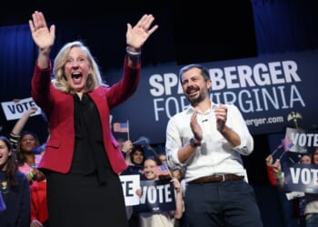 A man and woman with their hands up
