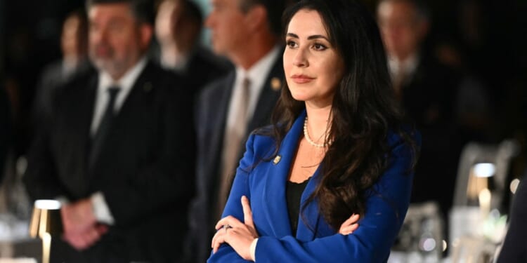 A woman in a blue suit with her arms crossed