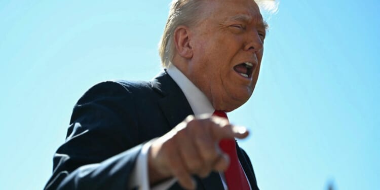 A man in a suit pointing at something