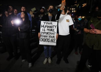 A group of people holding a sign