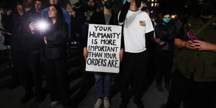 A group of people holding a sign