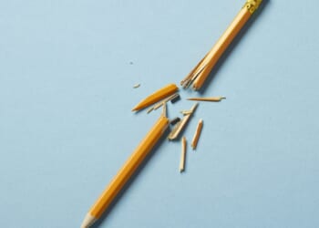 A yellow broken pencil on a blue background