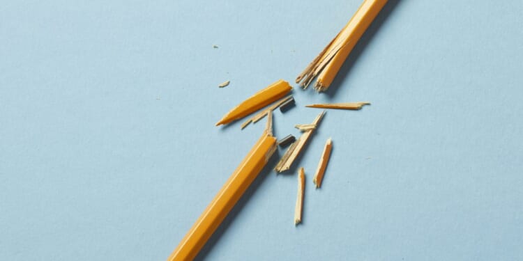 A yellow broken pencil on a blue background