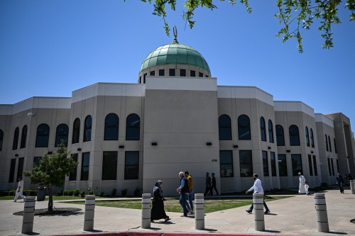 A group of people walking in front of a building