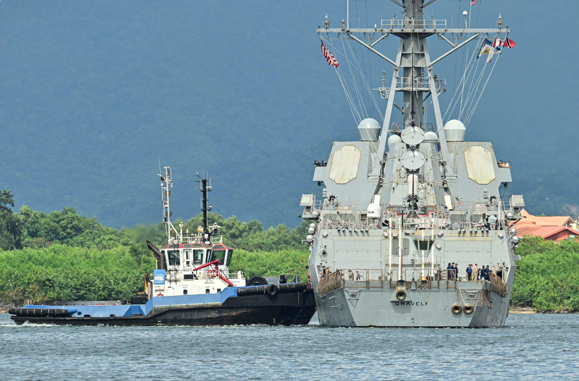 A tugboat next to a large ship