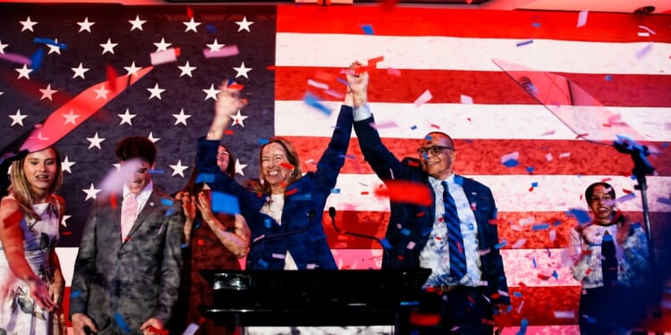 A group of people standing at a podium with confetti falling