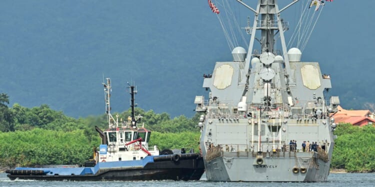 A tugboat next to a large ship
