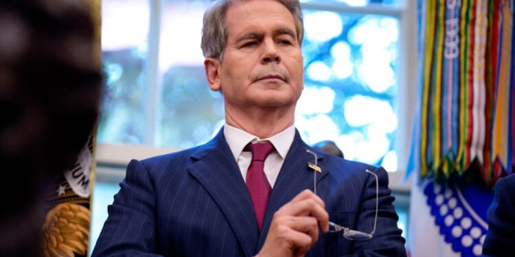 A man in a suit holding glasses