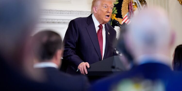 A man in a suit speaking into a microphone