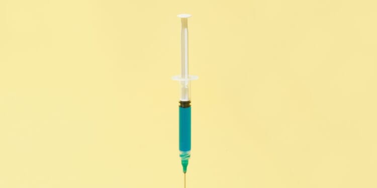 A floating syringe on a yellow background