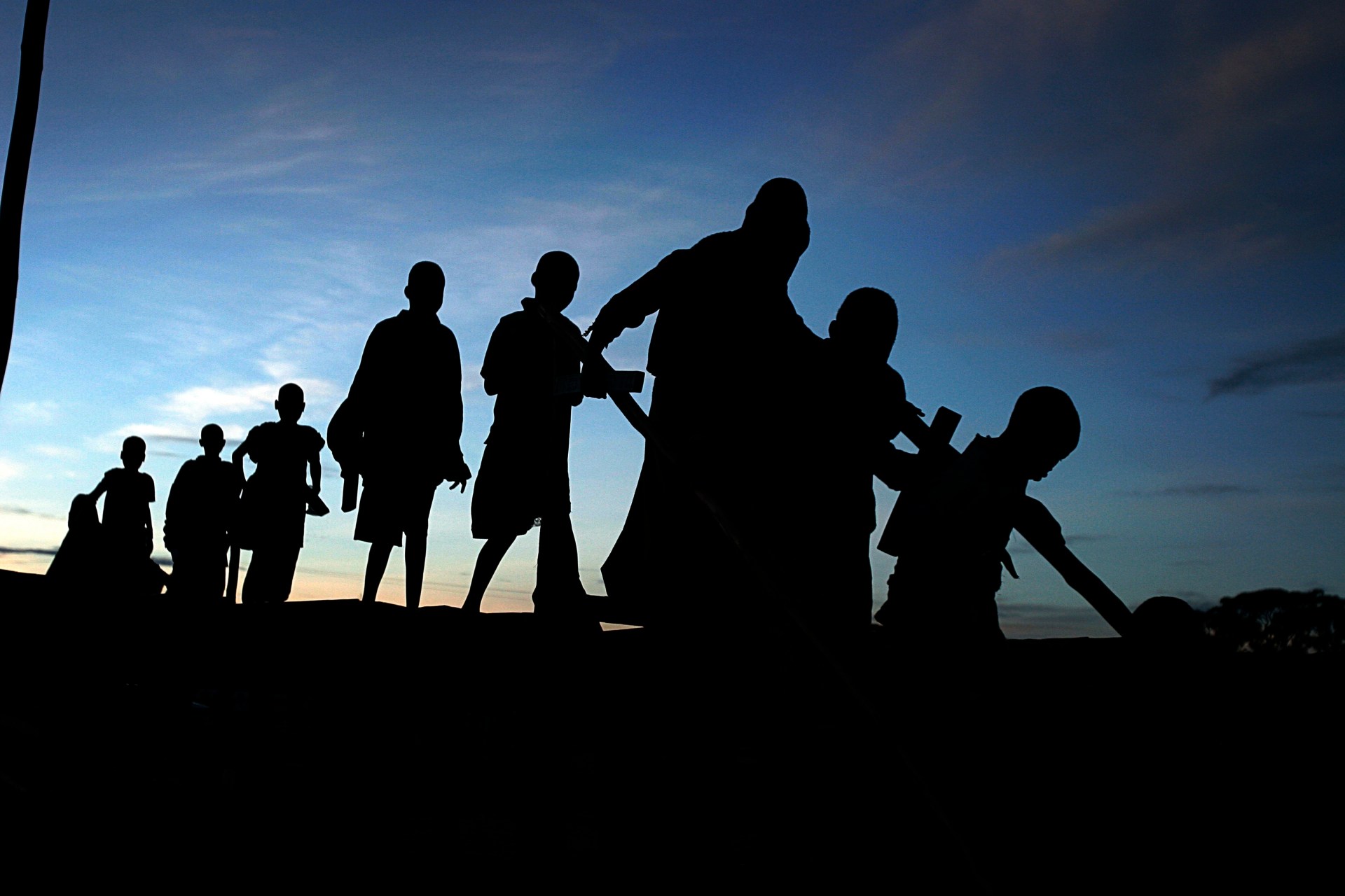 Children leave a shelter to walk back to their villages as the sun rises on May 27, 2005, in Gulu, Uganda. (Photo by Per-Anders Pettersson/Getty Images)