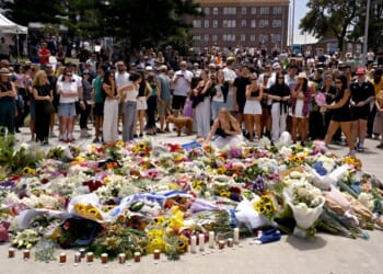Mourners gather by floral tributes at the Bondi Pavillion in memory of the victims of a shooting at Bondi Beach, in Sydney on December 15, 2025. (Photo by Saeed KHAN / AFP via Getty Images)
