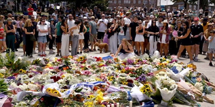Mourners gather by floral tributes at the Bondi Pavillion in memory of the victims of a shooting at Bondi Beach, in Sydney on December 15, 2025. (Photo by Saeed KHAN / AFP via Getty Images)