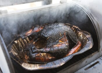 Smoked turkey cooking outdoor on a grill and smoker combination