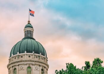 USA and Indiana Flag atop the State Capitol building in Indianapolis, Indiana at Sunset