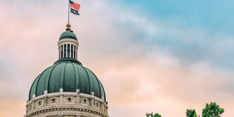USA and Indiana Flag atop the State Capitol building in Indianapolis, Indiana at Sunset