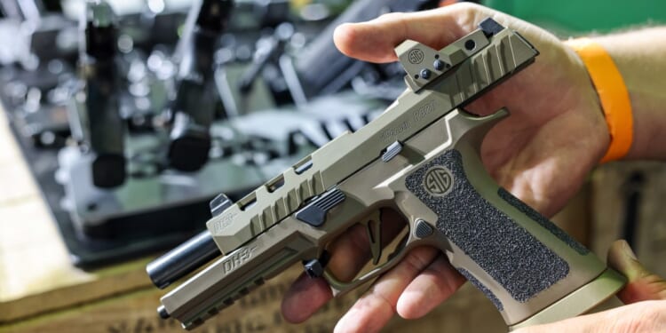 A man shows a SIG Sauer P320 DH3 pistol on 27 September 2024. (Photo by Jan Woitas/picture alliance via Getty Images)