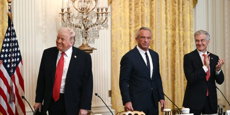 President Donald Trump, Secretary of Health and Human Services Robert F. Kennedy Jr., and Medicare and Medicaid Administrator Mehmet Oz, in the East Room of the White House in Washington, D.C. on January 16, 2026. (Photo by Brendan SMIALOWSKI/AFP/Getty Images)