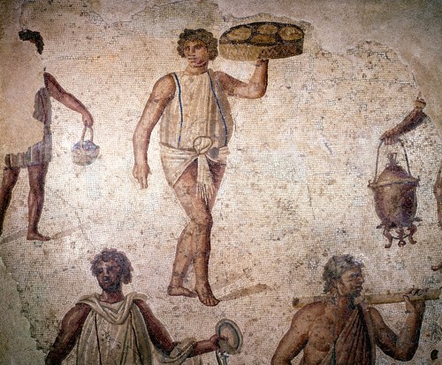 Ancient Roman mosaic depicting a servant or attendant holding a tray of bread while surrounded by other figures in classical dress engaged in various activities.