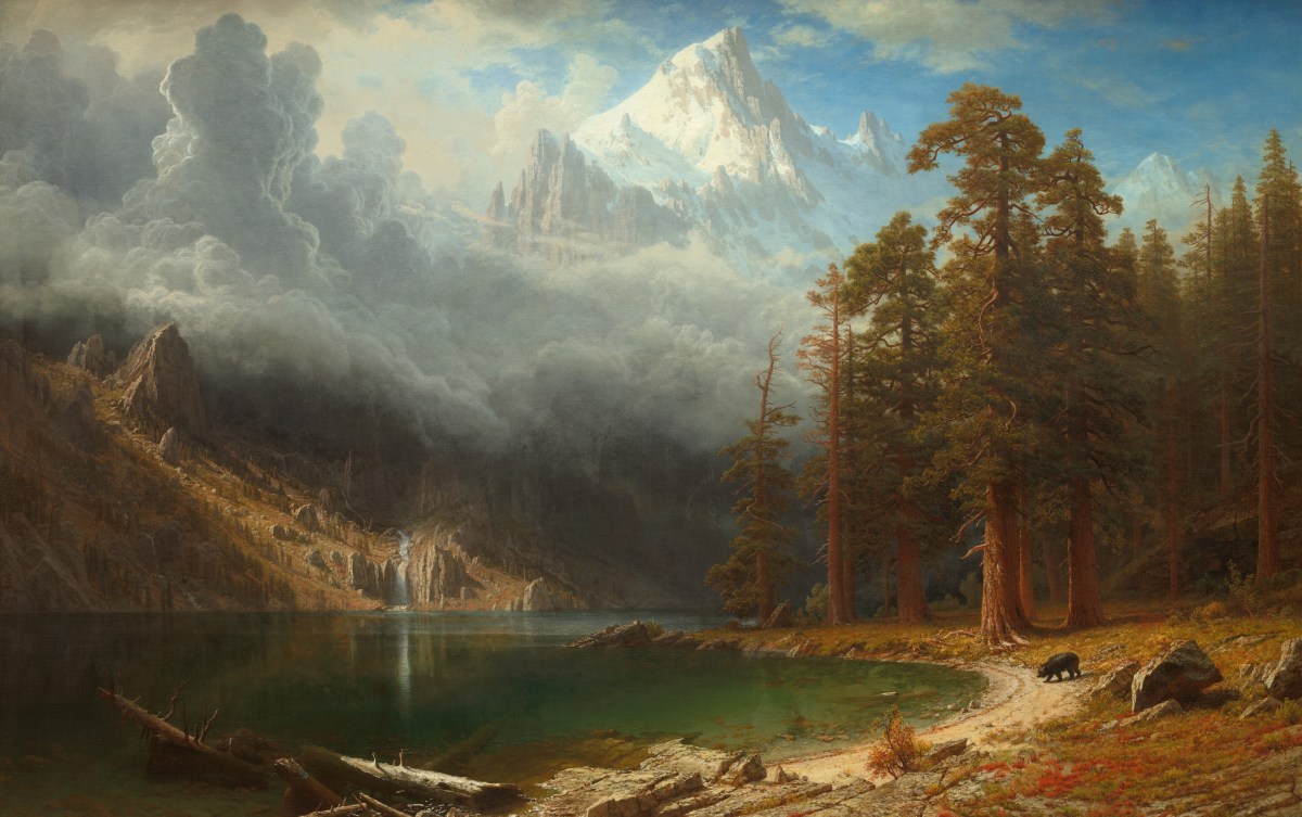 # Alt Text A majestic mountain landscape featuring a pristine alpine lake surrounded by towering pine forests, with snow-capped peaks rising dramatically in the background under a cloudy sky.
